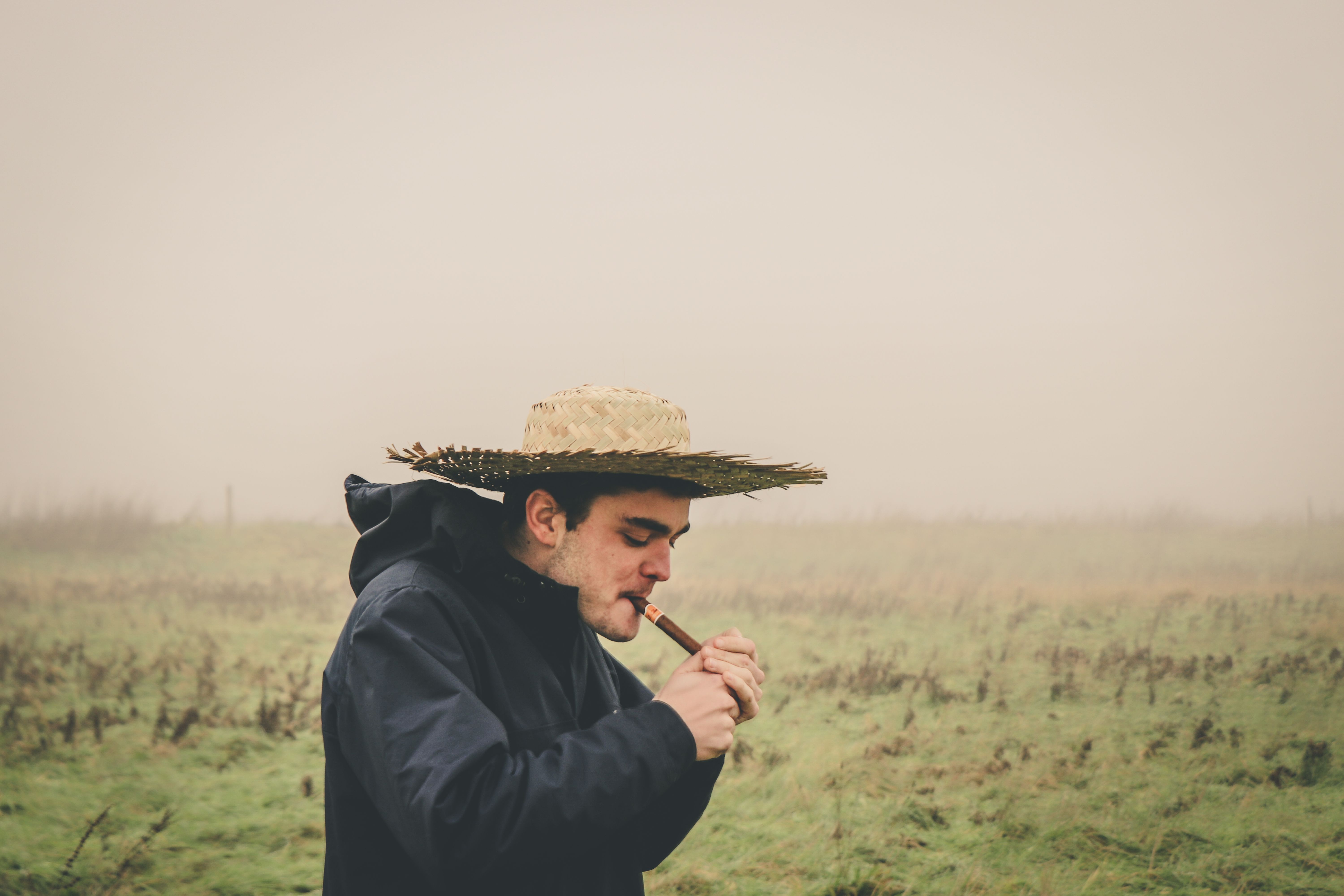 man lighting cigar outdoors in windy weather