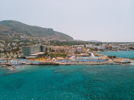 Stunning aerial shot of a luxurious coastal resort in Greece with mountains in the background.
