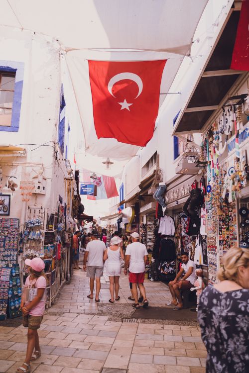 Free Bustling street market in Bodrum with Turkish flags and diverse souvenirs for sale. Stock Photo