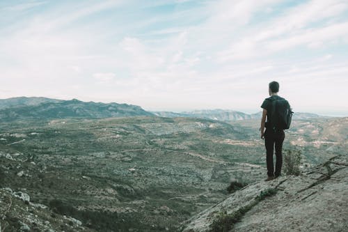 Free Man Standing on the Mountains Stock Photo