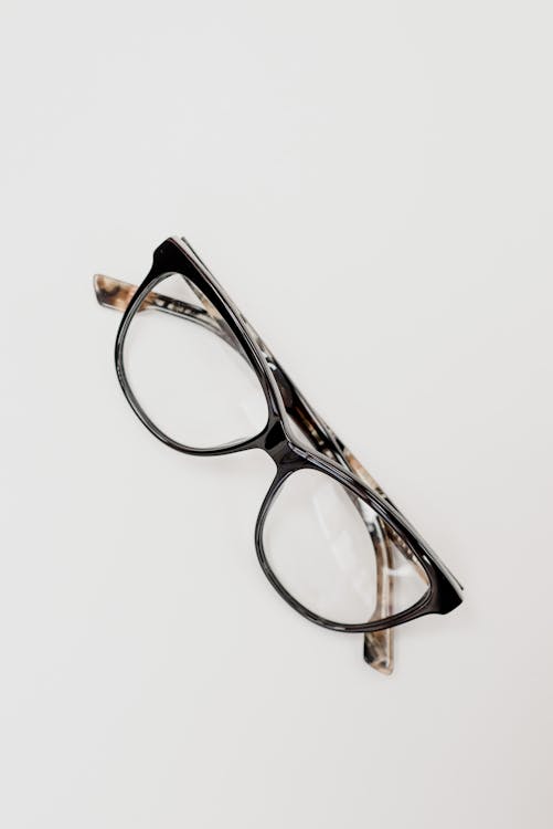 From above of glasses for correcting eyesight in trendy rim placed on white table