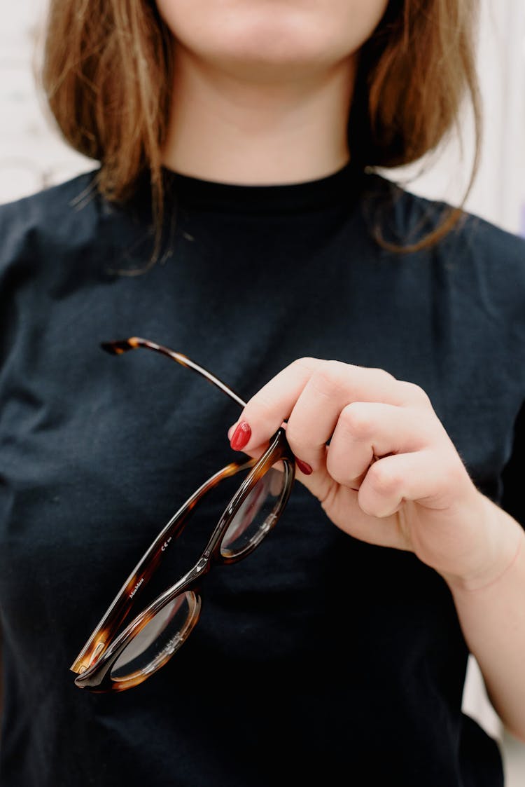 Woman With Eyeglasses In Hands In Optical Shop