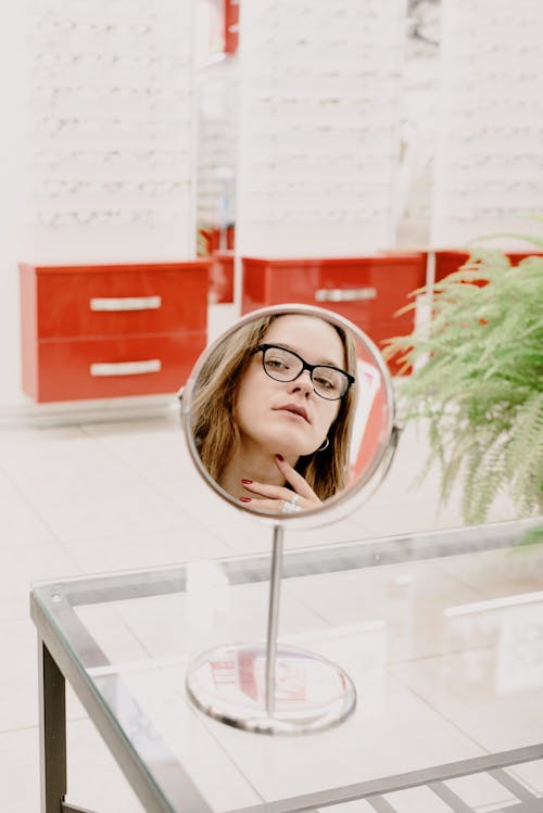 Woman choosing eyeglasses in optical salon
