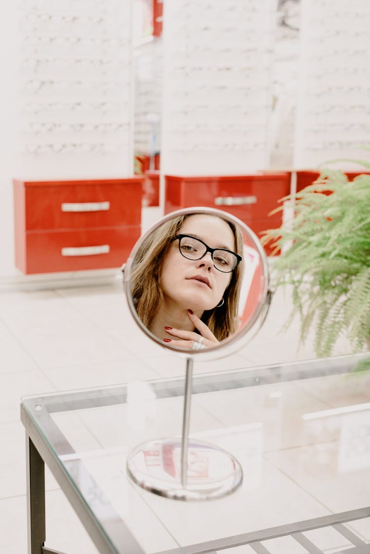 Woman Choosing Eyeglasses In Optical Salon