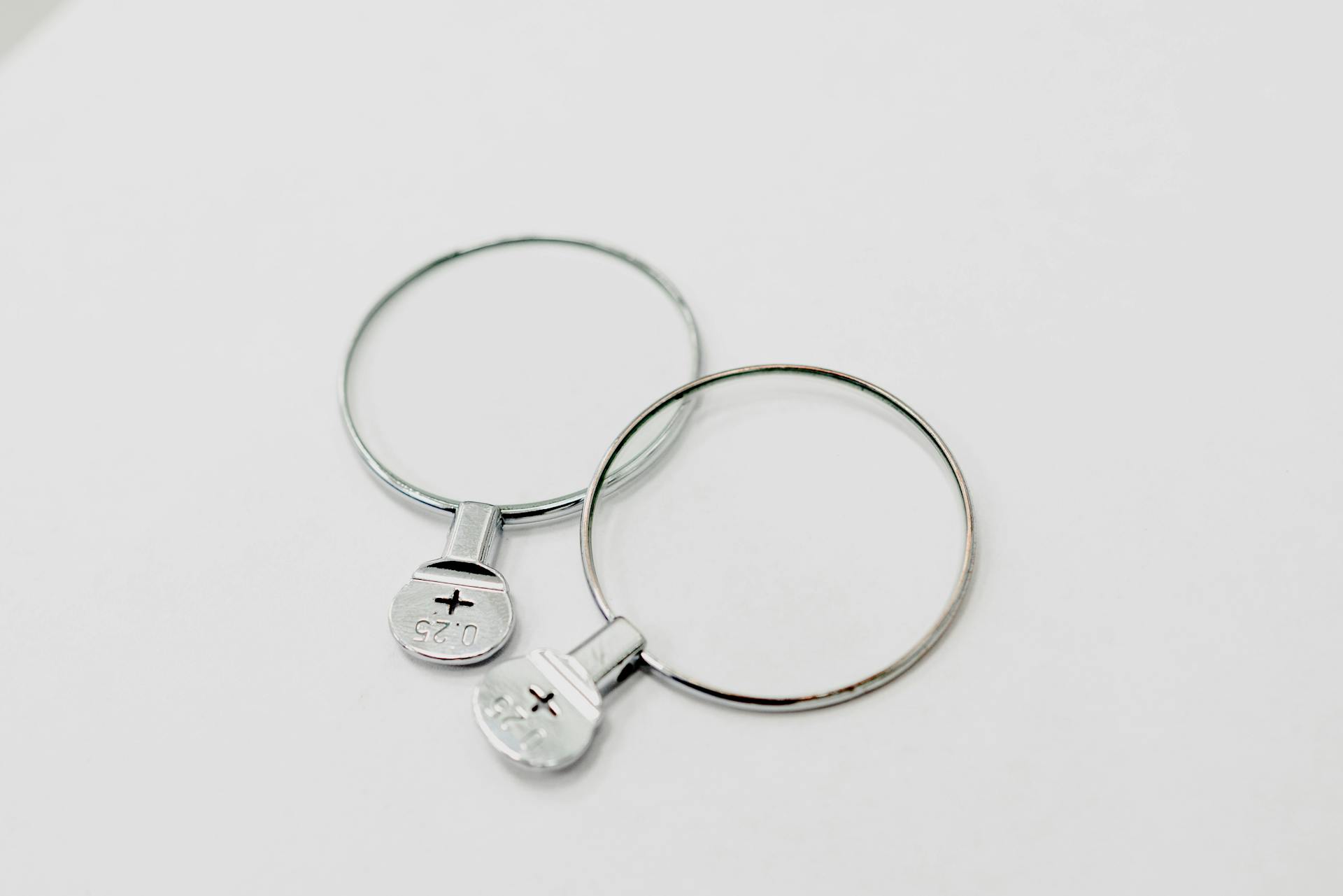 From above of glass trial spectacle lenses for eye examination placed on white surface in ophthalmological salon