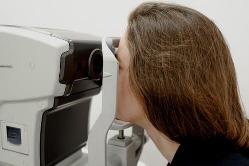 Free Woman checking eyesight on modern equipment Stock Photo