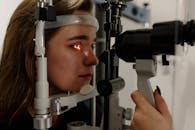 Woman testing vision on microscope