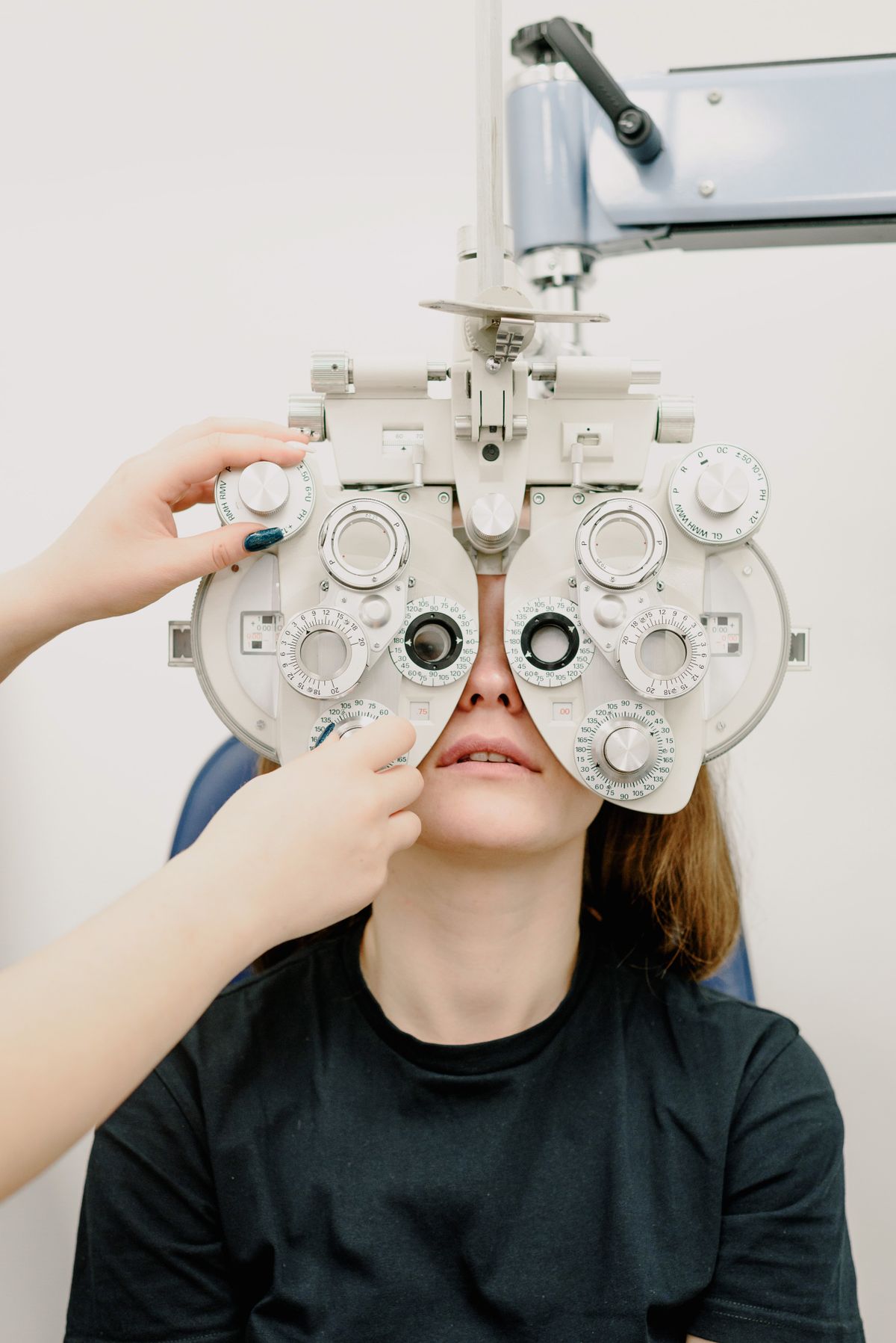Patient at an eye exam behind a phoropter