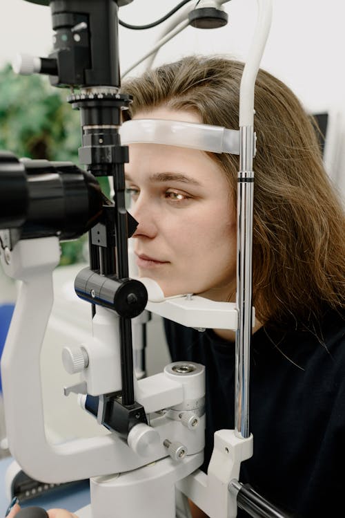 Free Woman examining vision with microscope Stock Photo