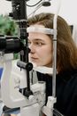 Woman examining vision with microscope
