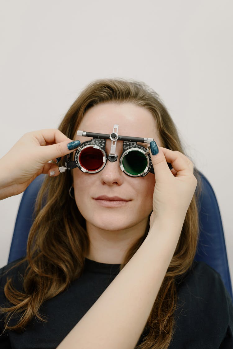 Crop Ophthalmologist Adjusting Ophthalmic Glasses On Woman