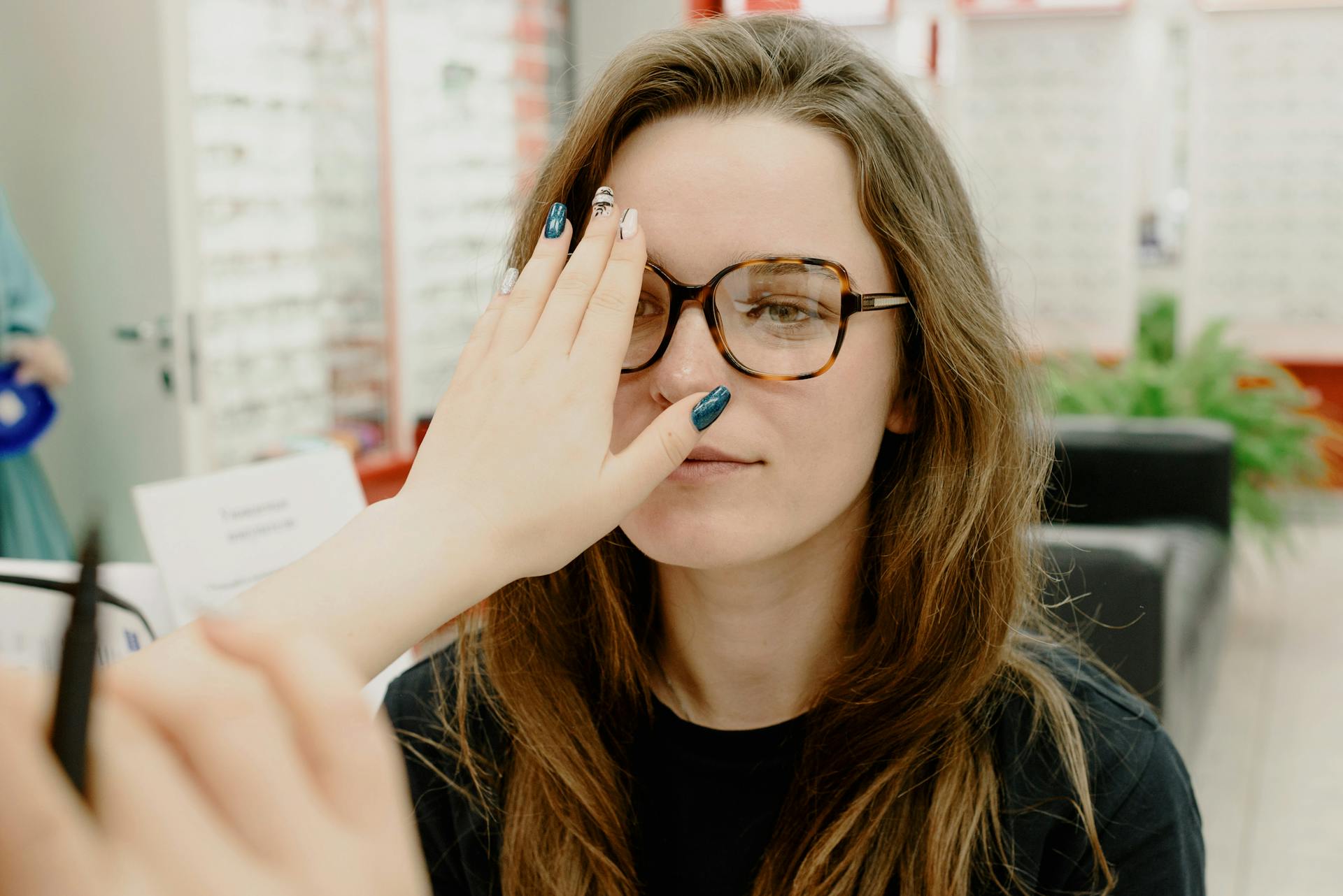 A woman receives an eye exam from an optometrist in a clinic setting.