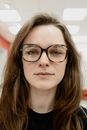 Content woman wearing eyeglasses in optical clinic