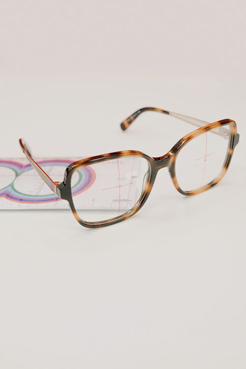 Modern eyeglasses with lens ruler on white background