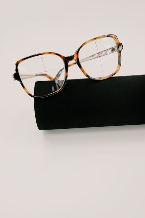 Modern eyewear with blots on plastic frame on closed black case on white background