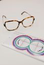 Professional lens ruler near modern eyeglasses on table