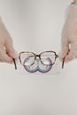 Crop ophthalmologist measuring eyewear with optical instrument