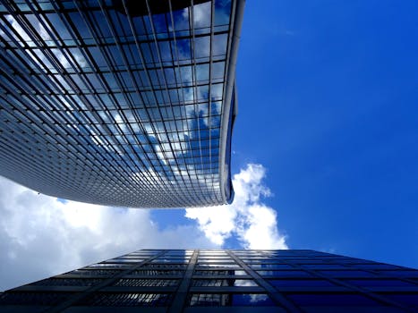 低角度拍摄的现代摩天大楼，反光玻璃映衬着清澈的蓝天