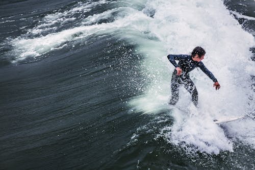 Photo of a Person in a Wetsuit Surfing