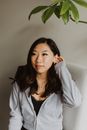 Positive Asian woman tucking hair behind ear