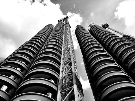 一张引人注目的黑白照片捕捉了起重机背靠天空的摩天大楼建设场景