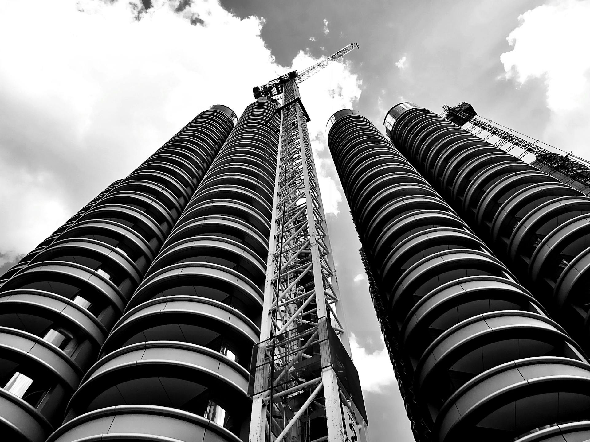 A striking black and white photo capturing skyscraper construction with cranes against the sky.