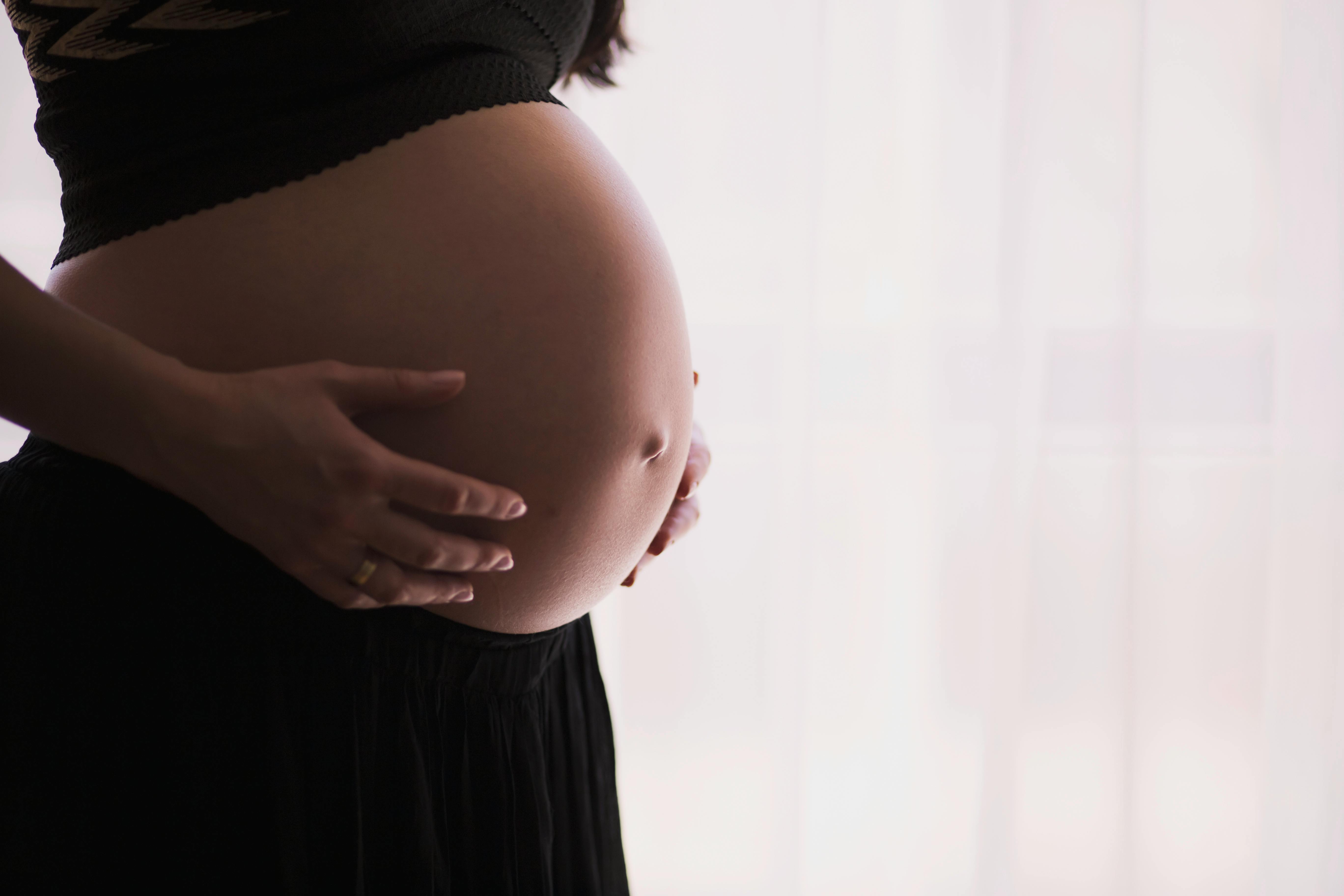 Pregnant woman holding her tummy | Photo: Pexels