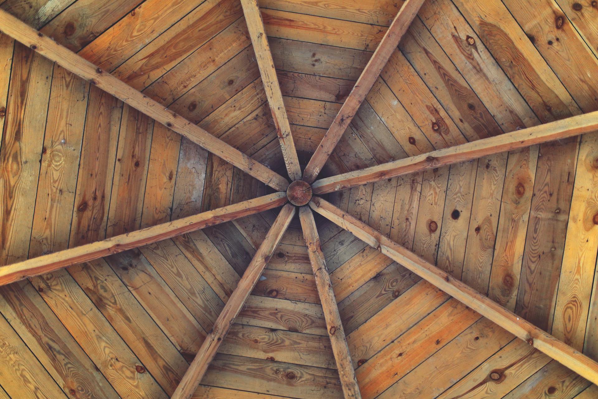 A rustic wooden ceiling displaying a geometric pattern with natural textures and tones.