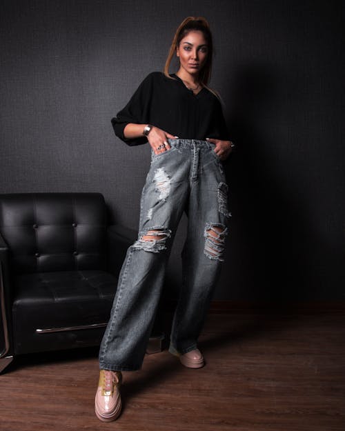 Photograph of a Woman Wearing a Black Top and Denim Jeans