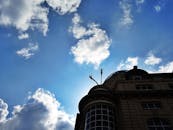 建筑的轮廓映衬在充满活力的蓝天和云层中，细节清晰可见