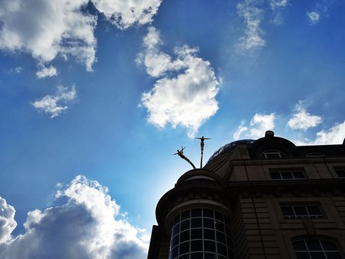 Free Striking silhouette of a building against a vibrant blue sky with clouds, showcasing architectural detail. Stock Photo