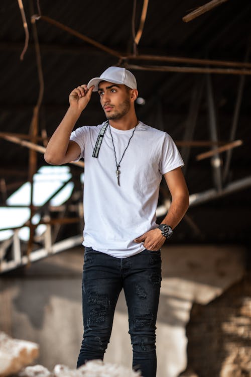 A Good-Looking Man in White Crew Neck T-shirt and Denim Jeans Wearing White Cap · Stock Photo