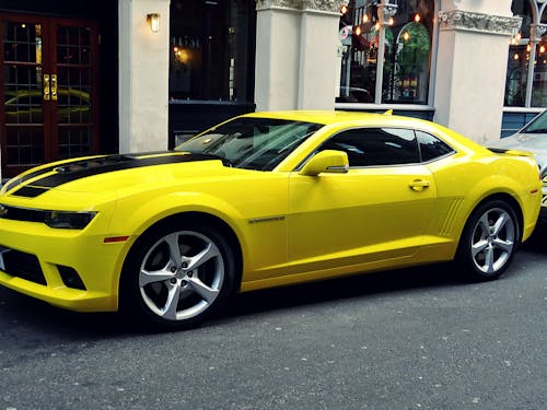 Free Yellow Chevroelt Camaro Parked Outside of Building Stock Photo