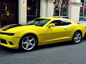 Yellow Chevroelt Camaro Parked Outside of Building