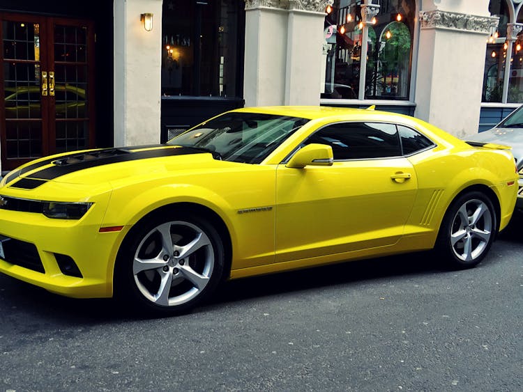 Yellow Chevroelt Camaro Parked Outside Of Building