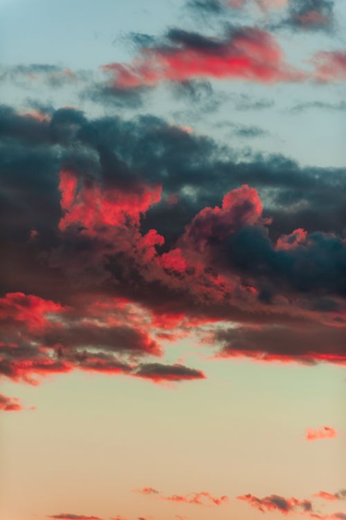 Free Captivating sunset scene with vivid red and orange clouds contrasting a soft sky. Stock Photo
