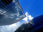 现代摩天大楼的低角度视图映照着蓝天白云，展现出建筑设计的魅力