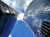 低角度镜头下，现代摩天大楼令人惊叹，玻璃外墙倒映着蓝天