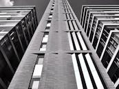 一张黑白照片，展现出现代摩天大楼的几何图案和玻璃立面