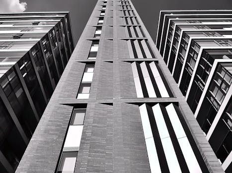 一张黑白照片，展现出现代摩天大楼的几何图案和玻璃立面