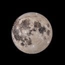 From below of black and white of full moon with craters shining in dark endless sky at night