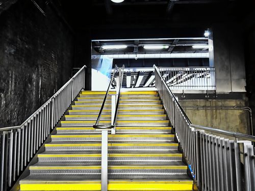 Free Contemporary indoor staircase featuring stainless steel railings and modern lighting. Stock Photo