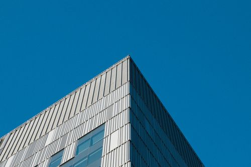 Free Low-angle view of a modern building with geometric patterns against a clear blue sky in Montréal, Canada. Stock Photo