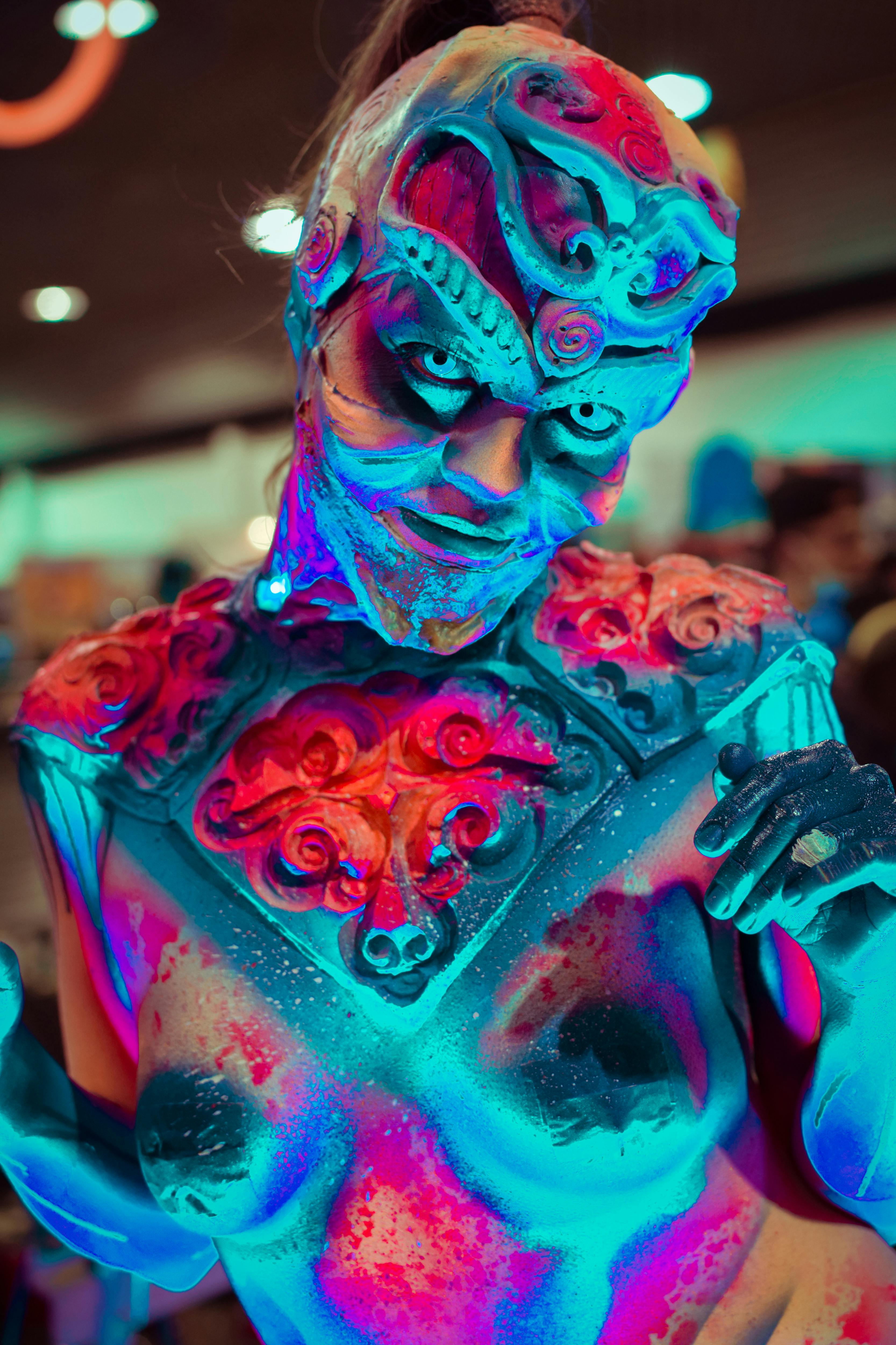 Close-up of a person in creative Halloween costume with colorful prosthetic makeup.