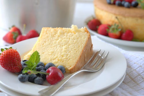 Sliced Cake and Fruits on White Ceramic Plate