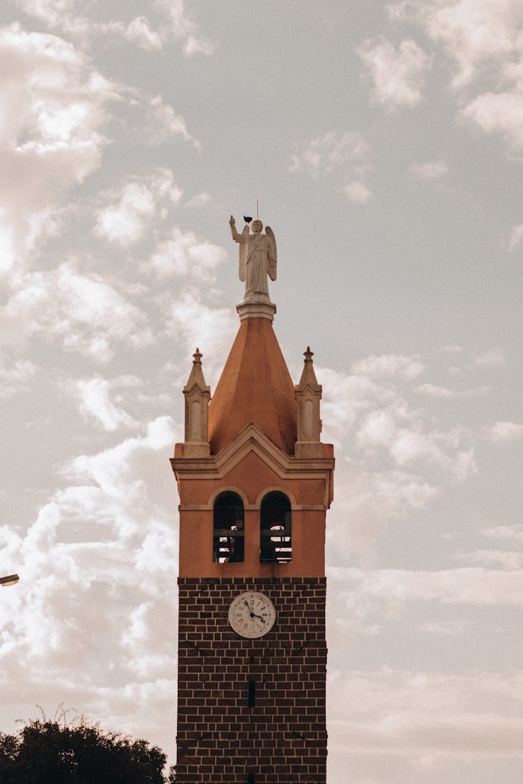 Brick Clock Tower With Sculpture