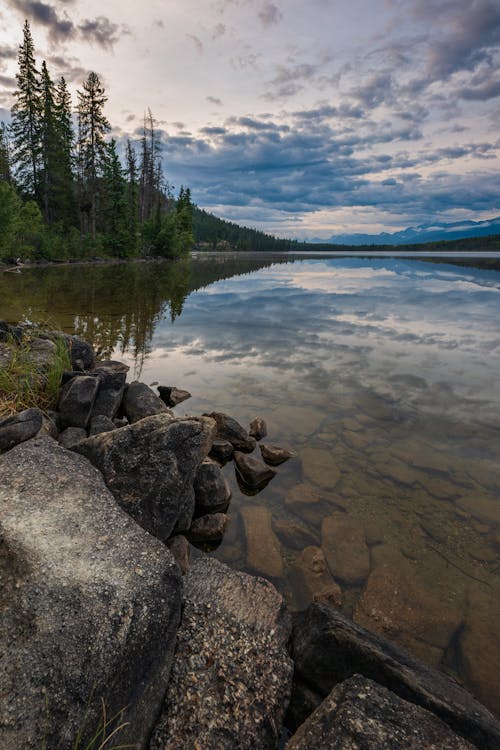 Rocks on Calm Lake under the Cloudy Sky