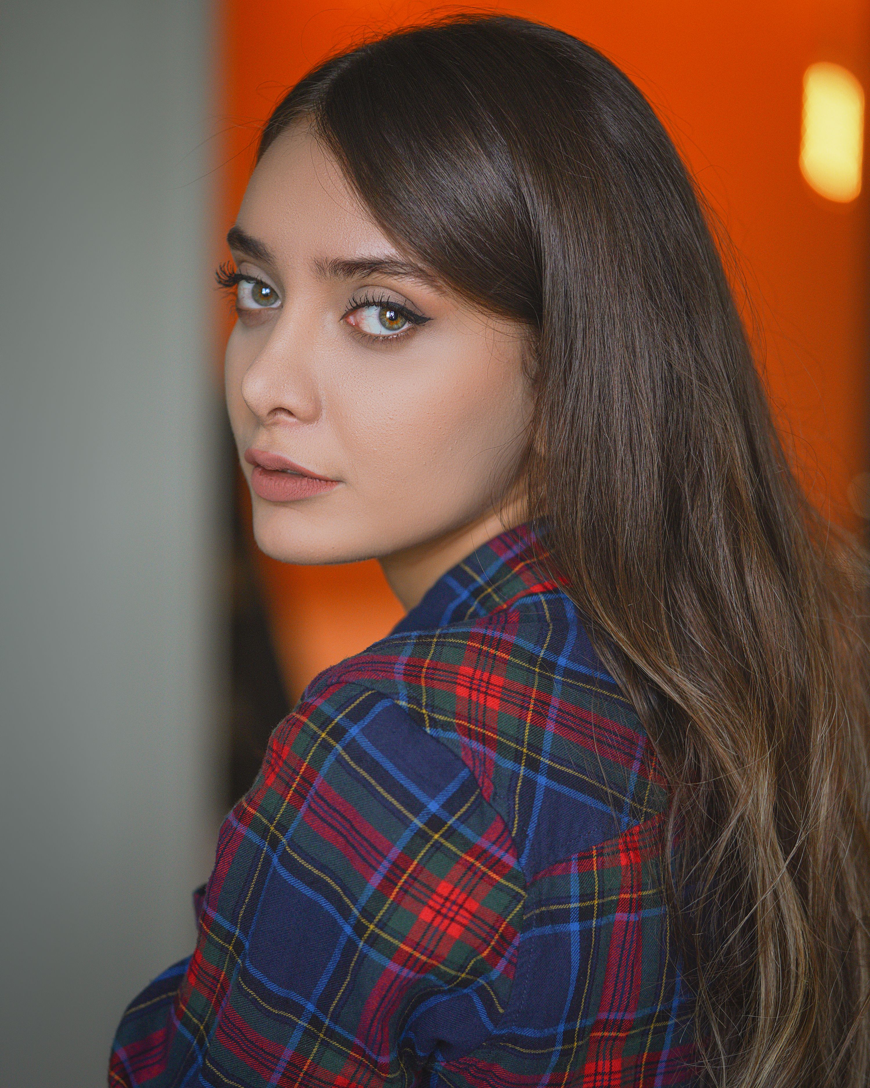 Charming portrait of a woman wearing a plaid shirt, captured indoors in Tehran, Iran.
