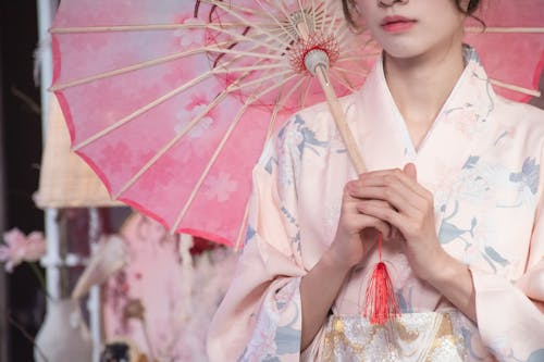 Free Woman in Floral Kimono Holding a Traditional Paper Umbrella Stock Photo