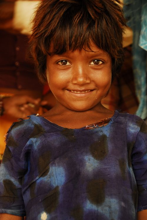Free A joyful child with a charming smile in a colorful blue shirt portrait. Stock Photo